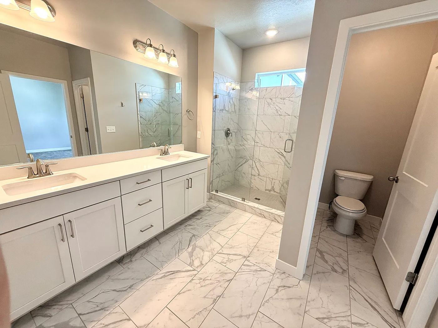 Primary bath: glass, tile and fixtures sparkling